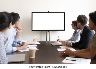 Business Executive People Group Sitting At Conference Table Looking At White Blank Mockup Tv Screen On Wall Watching Presentation In Meeting Room, Company Training Corporate Team Seminar In Boardroom