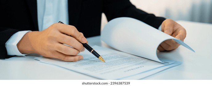 Business executive signing contract agreement document on the bale with the help from company attorney or lawyer service in law firm office. Business investing and finalizing legal processing. Shrewd - Shutterstock ID 2396387539