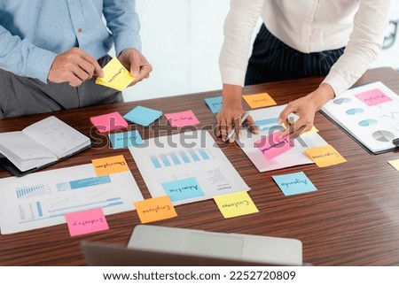 Business executive team brainstorm and takes notes on keyword about a new business project for marketing planning together in the office.
