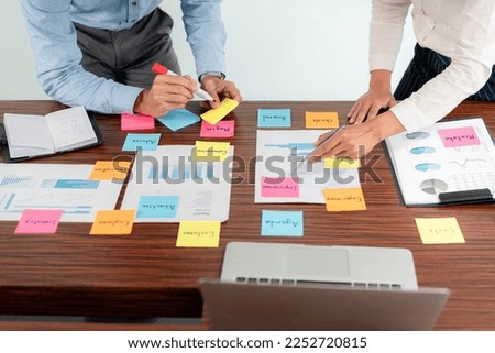 Business executive team brainstorm and takes notes on keyword about a new business project for marketing planning together in the office.