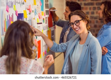 Business Executives Looking At Sticky Notes On Whiteboard In Office