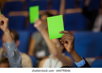 Business executives show their approval by raising hands at conference center - Powered by Shutterstock