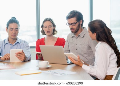 Geschäftsleute, die Laptop und digitale Tablette im Konferenzraum im Büro einsetzen