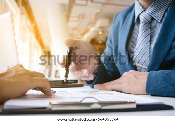 Business Executives working a big job,\
discussing sales performance in a modern\
office.