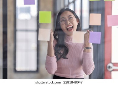 Business female employee with many conflicting priorities arranging sticky notes commenting and brainstorming on work priorities colleague in a modern office.
 - Shutterstock ID 2281848049