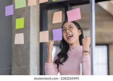 Business female employee with many conflicting priorities arranging sticky notes commenting and brainstorming on work priorities colleague in a modern office.
 - Shutterstock ID 2282265495