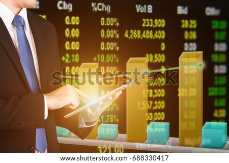 Business and Finance concept. Businessman touching tablet with a large display of daily stock market price and quotations. Double exposure of businessman with bargraph digital display as background.