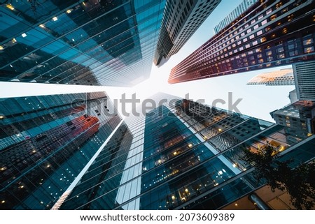 Business and finance concept, looking up at high rise office buildings at sunset in the financial district of a modern metropolis.