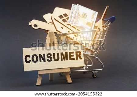 Business and finance concept. On a black background, there is a shopping cart with purchases, next to an easel and a sign with the inscription - CONSUMER