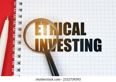 Business And Finance Concept. On The Red Surface Is A Pen, A Notepad With The Inscription - Ethical Investing And A Magnifying Glass