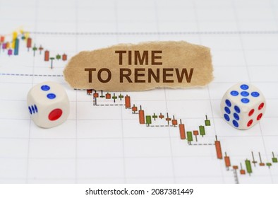 Business and finance concept. On the trading charts, there are dice and pieces of paper with the inscription - TIME TO RENEW