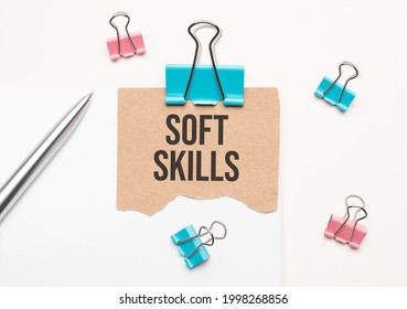 Business And Finance Concept. On A White Background Lies A Notebook, A Pen, Clothespins And Cardboard With The Inscription - Soft Skills