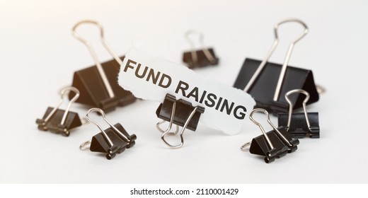 Business And Finance Concept. On A White Table There Are Office Clamps, In One Clip There Is Paper With The Inscription - FUND RAISING