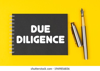 Business And Finance Concept. On A Yellow Background Lies A Pen And A Black Notebook With The Inscription - Due Diligence