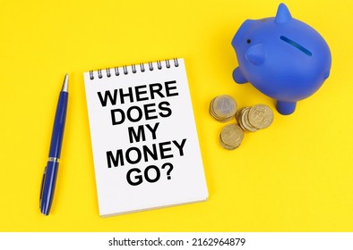 Business and finance concept. On a yellow surface, a piggy bank, coins and a notepad with the inscription -WHERE DOES ALL MY MONEY GO