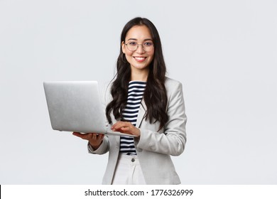 Business, finance and employment, female successful entrepreneurs concept. Confident smiling asian businesswoman, office worker in white suit and glasses using laptop, help clients - Shutterstock ID 1776326999