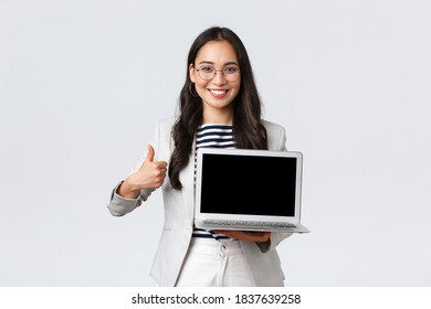 Business, Finance And Employment, Female Successful Entrepreneurs Concept. Professional Real Estate Broker Showing Houses To Clients On Laptop Screen, Make Thumbs-up Gesture, Recommend Deal