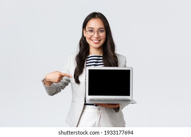 Business, Finance And Employment, Female Successful Entrepreneurs Concept. Professional Real Estate Broker Showing Houses To Clients On Laptop Screen, Pointing At Display, Recommend Deal