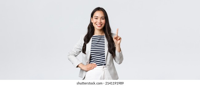 Business, finance and employment, female successful entrepreneurs concept. Good-looking confident female asian real estate broker being number one, offer good deal, showing finger and smiling - Shutterstock ID 2141191989