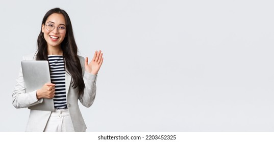 Business, finance and employment, female successful entrepreneurs concept. Friendly smiling office manager greeting new coworker. Businesswoman welcome clients with hand wave, hold laptop