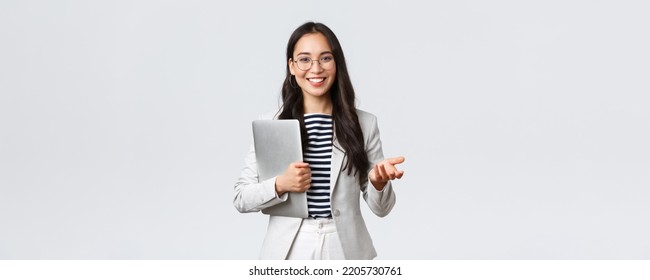 Business, finance and employment, female successful entrepreneurs concept. Smiling professional businesswoman, real estate broker showing clients good deal, carry laptop in hand - Powered by Shutterstock