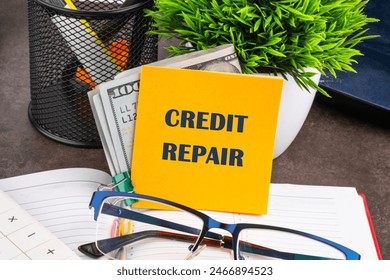 Business, finance and fix your credit here concept. Concept words CREDIT REPAIR on a yellow sticker with dollars, on the desktop of a businessman, manager
