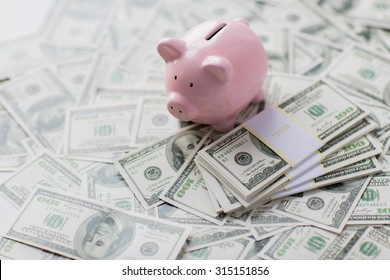 business, finance, investment, saving and corruption concept - close up of dollar cash money and piggy bank on table