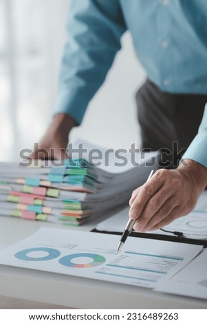 A business finance man is reviewing a company's financial documents prepared by the Finance Department for a meeting with business partners. Concept of validating the accuracy of financial numbers.