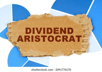 Business And Finance. On The Blue Financial Charts Is A Piece Of Cardboard That Says - Dividend Aristocrat