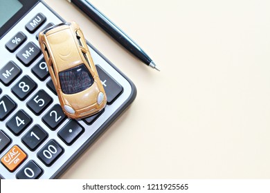 Business, finance, saving money, banking or car loan concept : Top view or flat lay of miniature car model, calculator and pen on office desk table with copy space ready for adding or mock up