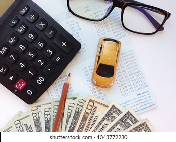 Business, Finance, Saving Money Or Car Loan Concept : Top View Or Flat Lay Of Miniature Car Model, American Dollars Cash Money, Calculator And Saving Account Book Or Financial Statement On Office Desk