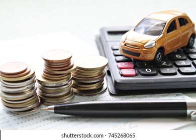 Business, finance, saving money or car loan concept : Miniature car model, coins stack, calculator and saving account book or financial statement on office desk table