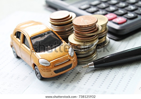 Business, finance, saving money\
or car loan concept : Miniature car model, coins stack, calculator\
and saving account book or financial statement on desk\
table