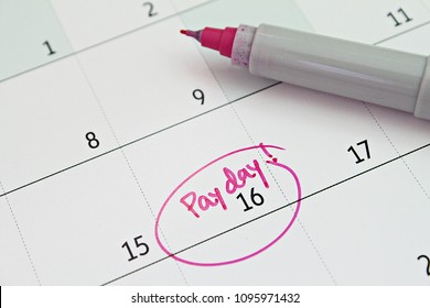 Business, finance, savings money, wages, payroll or accounting concept : Calendar with pink marker circle in word payday for remind