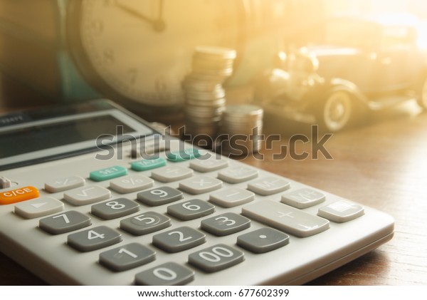 Business Finance,Auto loan and car\
insurance,Calculator with toy car and Coin on wood\
top