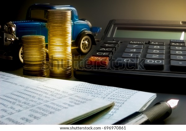 Business Finance,Auto loan and car\
insurance,Calculator with toy car on Black\
floor