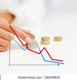 business, finances, crisis, people and money saving concept - close up of graph and female hand putting euro coins into columns in office - Powered by Shutterstock