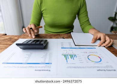 Business financing accounting banking concept. Business woman hand doing finances and calculate on desk about cost at home office. Woman working on desk with using calculator, finance accounting.