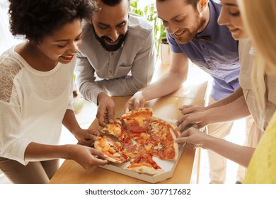 business, food, lunch and people concept - happy business team eating pizza in office - Powered by Shutterstock