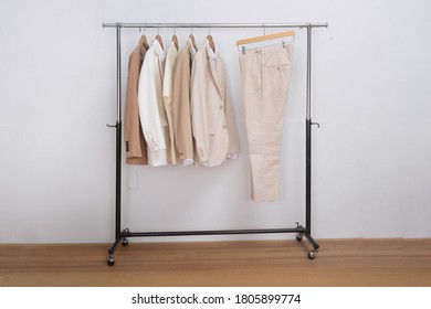 Business Formal Linen Suit With White Shirt And Pants On Hanger-wooden Background

