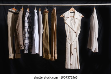 Business Formal Striped ,gray Suit With White Shirt And Khaki Pants And Woman Dress On Hanger-black Background