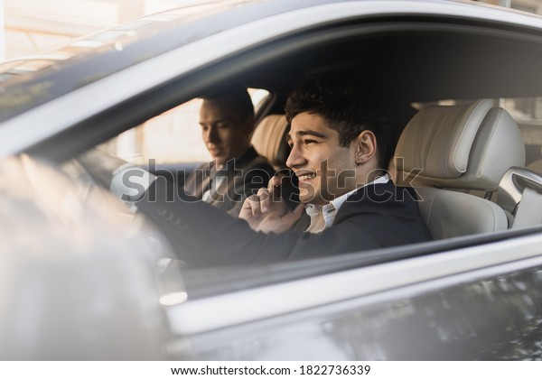 business formal suit goes to work good mood.\
portrait of a young man of Caucasian appearance sitting in a car\
looking out the window and\
smiling.
