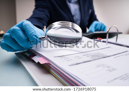 Business Fraud Investigation With Magnifying Glass In Gloves