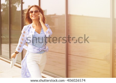Business and freelance concepts. Close-up portrait of executive working with a mobile phone in the street with office buildings in the background.