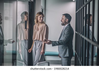 Business friendly man inviting his female colleague to office