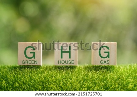 Business and GHG concept. Copy space. Greenhouse gas symbol. Concept words 'GHG, greenhouse gas' on cubes and blocks on a beautiful green background. 