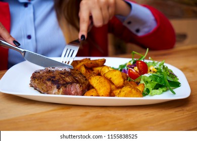 a business girl eats a steak at a restaurant