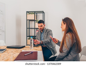 Business girl holding smartphone while sitting with her colleague - Shutterstock ID 1370462309