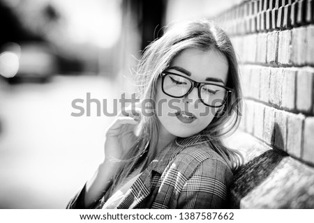 Business girl in a plaid jacket in the street with glasses