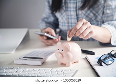 Business Girl Putting Coin In A Piggy Bank. Saving Money